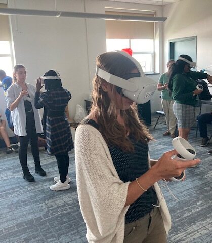 A 2022 Academy participant teacher tries out the virtual reality program showing a day in the life of a wind turbine maintenance & operations person